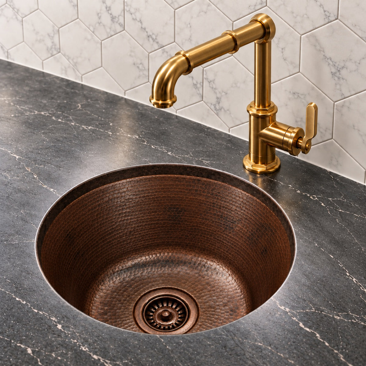 Round hammered antique copper bar sink undermounted in a black marble counter with a brass bridge bar faucet