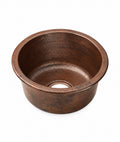 Round hammered antique copper bar sink with flat rim, side view on a white background