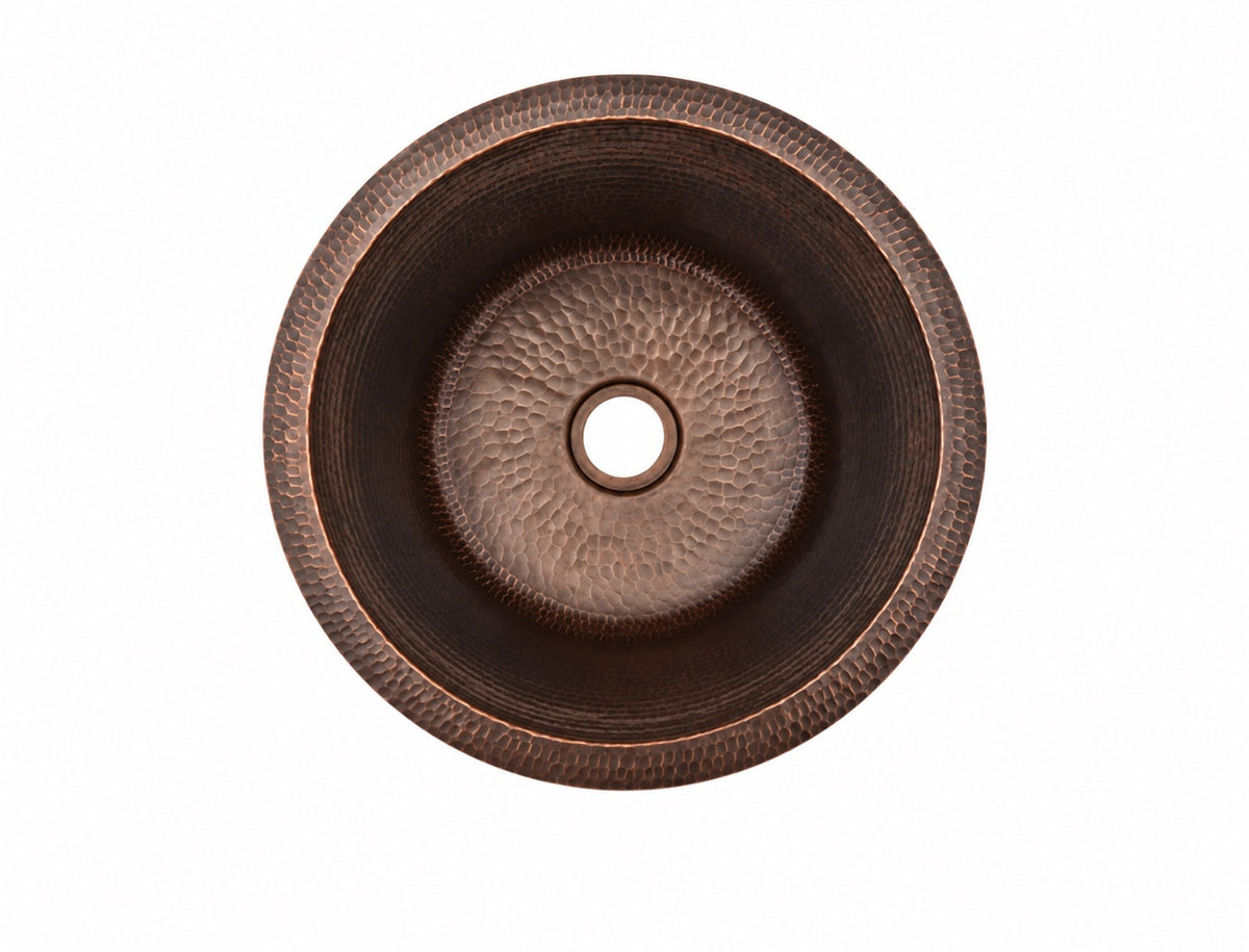 Round hammered antique copper bar sink, top view showing the dark antique patina and 3.5 inch drain opening
